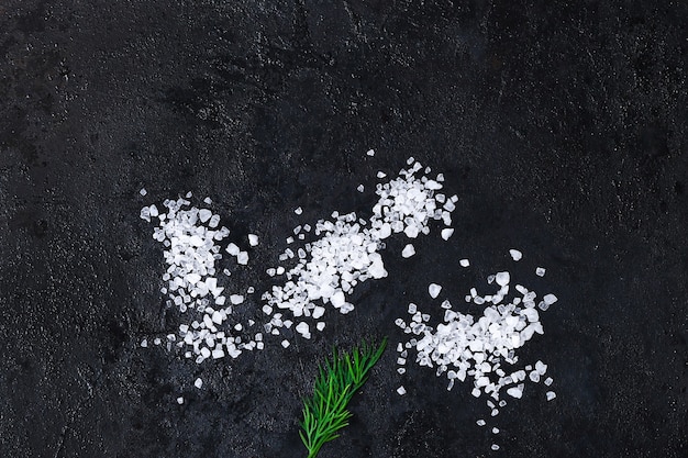 Фото Крупные кристаллы соли на черном столе