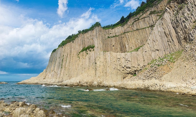 Coast of Kunashir Island with columnar basalt cliff Cape Stolbchaty