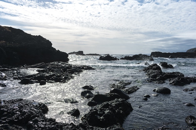 Costeggiare le rocce nelle azzorre. onde che si infrangono sulle rocce di basalto