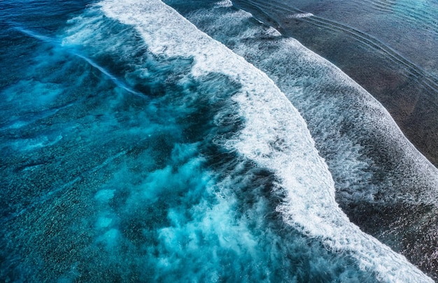 Coast with high waves as a background from top view Blue water background from top view Summer seascape from air Indonesia Travel and vacation image