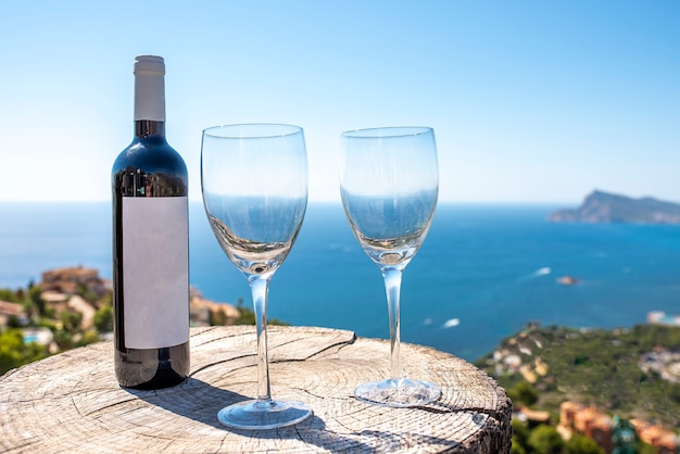 Coastal landscape with Bottle of wine with two glasses and the sea