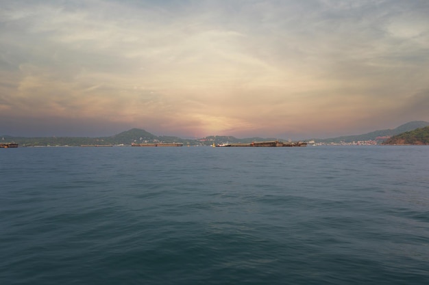 Coastal seas around Koh Sichang Thailand are crowded with cargo ships on a clear day