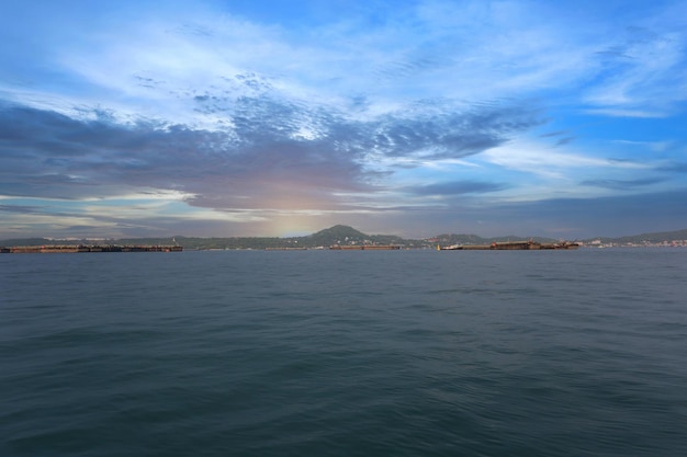 Coastal seas around Koh Sichang Thailand are crowded with cargo ships on a clear day