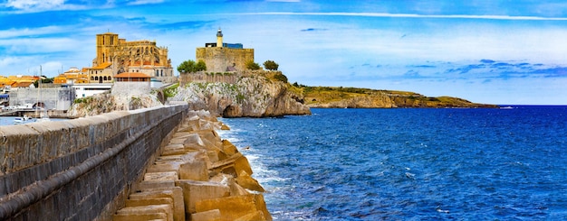 スペインの海岸沿いの町.カストロ・ウルディアレス.カンタブリア.教会と風景村の灯台