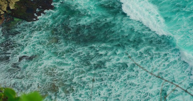 Coastline background Ocean power beach surf clear water wide sea wave with white foam splash washing rocky shore energy motion Summer vacation