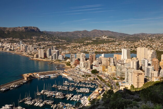 Coastline of the mediterranean resort of calpe spain with sea and yachts lake skyscrapers and mounta...