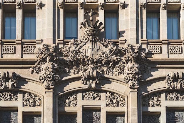 Foto stemma della città di barcellona scolpito nella facciata di un edificio modernista