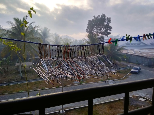 Foto coathangers en waspinnen op waslijn in de stad tijdens zonsondergang