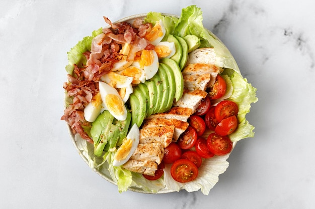 Cobb salade met bacon avocado tomaat gegrilde kip op marmeren achtergrond Klassieke Amerikaanse salade