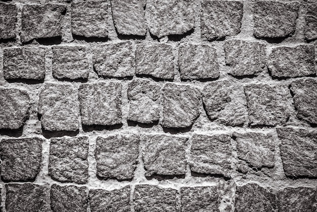 Cobblestone pavement texture background Detail of granite sidewalk Top view of stone road Vintage pavement with rough blocks