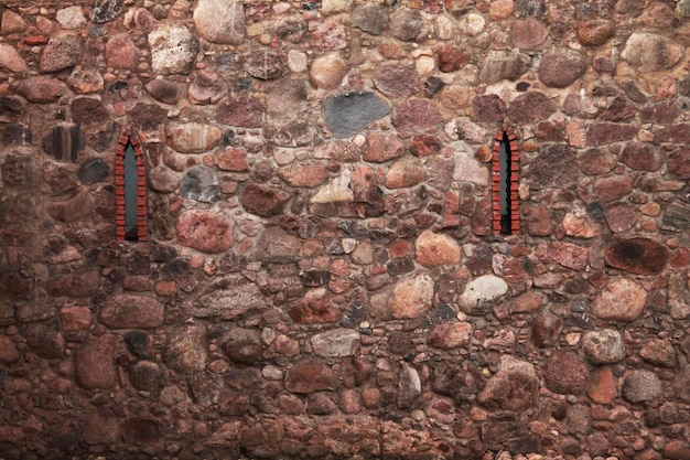 Cobblestone wall of the castle Texture of stone old masonry