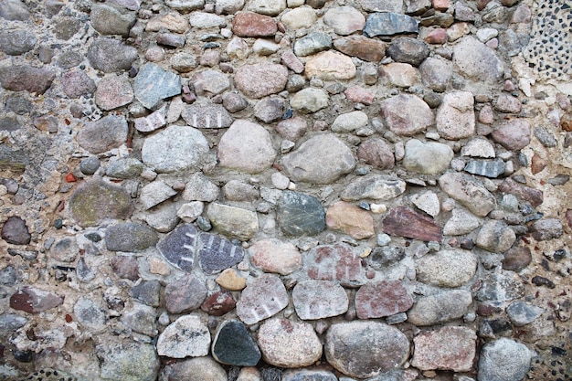 Cobblestone wall of a medieval castle Texture of stone old masonry