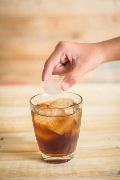 Coca Cola with ice on the wooden floor 