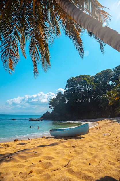 Photo cocalito beach in punta de sal and a local boat, tela. honduras