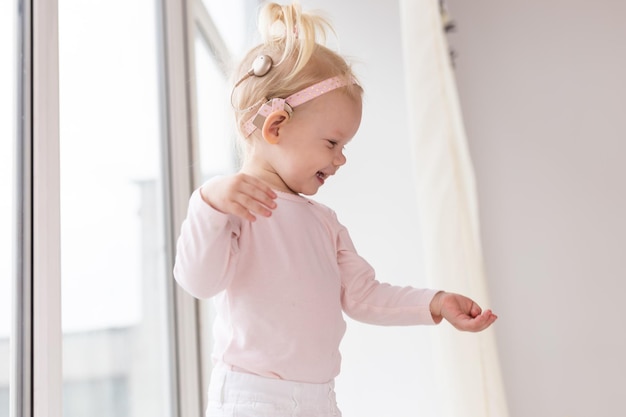 Cochlear implant for baby deaf child with hearing aid plays in living room health care and medicine