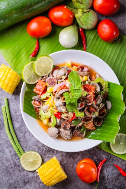 Foto cockle salad delizioso cibo tailandese posto sul tavolo decorato con varie giornate di cibo di verdure