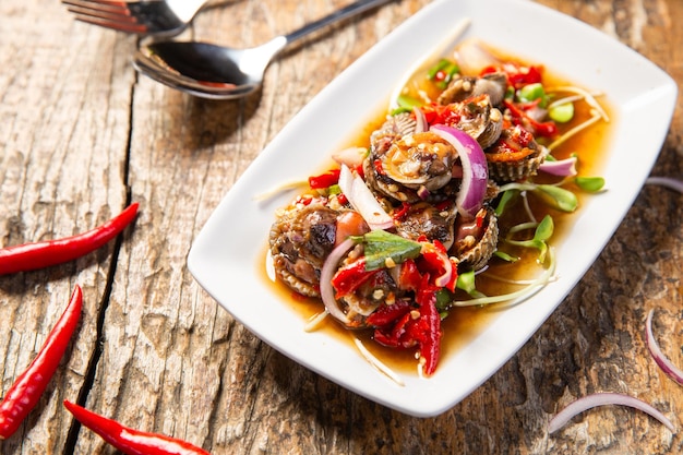 Foto cockle salad delizioso cibo tailandese posto sul tavolo decorato con varie giornate di cibo di verdure