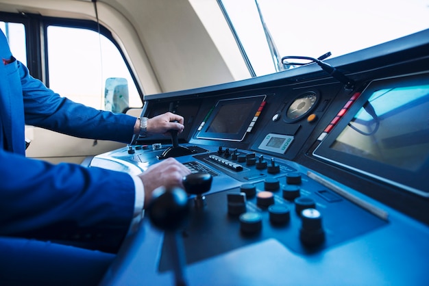 cockpit view of high speed subway train and an unrecognizable train driver pushing up the lever and accelerating the train.