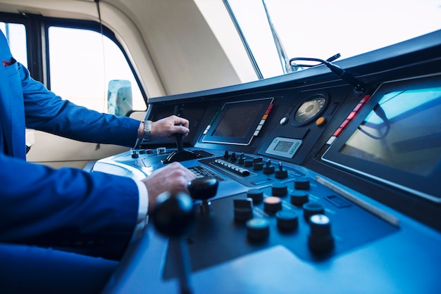 Cockpit view of high speed subway train and an unrecognizable train driver pushing up the lever and accelerating the train.