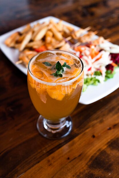 Foto cocktail accompagnato da cibo su un tavolo di legno
