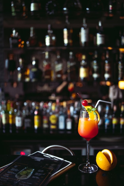 cocktail alcoholic drink with classic bar counter with bottles in blurred liquor interior bar background