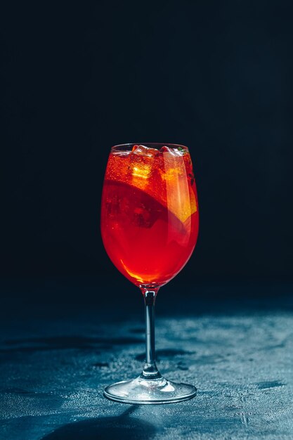 Foto cocktail aperol spritz su sfondo scuro cocktail alcolico estivo alla luce del sole con fette d'arancia cocktail italiano aperol spritz su tavola di ardesia bevanda alla moda