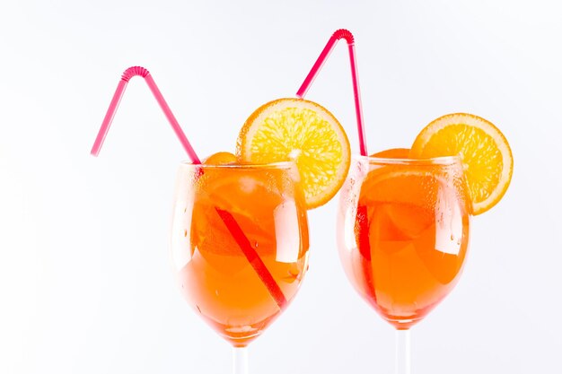 Коктейль Aperol spritz на белом фоне Аперол spritz коктейль с оранжевыми кусочками