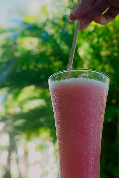 ヤシの木を背景にしたカクテルビーチでのさわやかなアイスドリンクでの休暇の気分