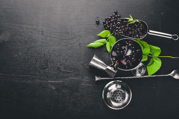 Cocktail di ribes nero fresco con ghiaccio su fondo di legno vista dall'alto spazio libero