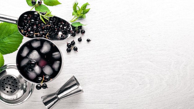 Cocktail of fresh black currant with ice on a wooden background Top view Free space