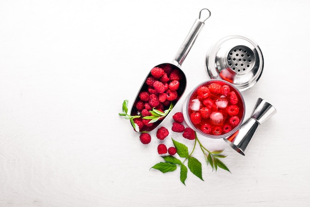 Cocktail of fresh raspberries with ice on a wooden background Top view Free space