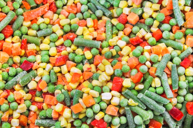 A cocktail of frozen chopped vegetables close-up as background