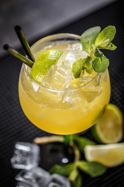 Cocktail garnished with a lime slice and mint leaf