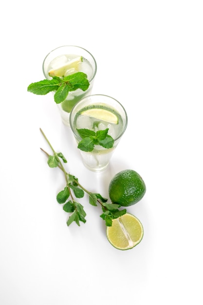 Cocktail Gin Tonic or Mojito in glass with mint, ice, lime on the white background.