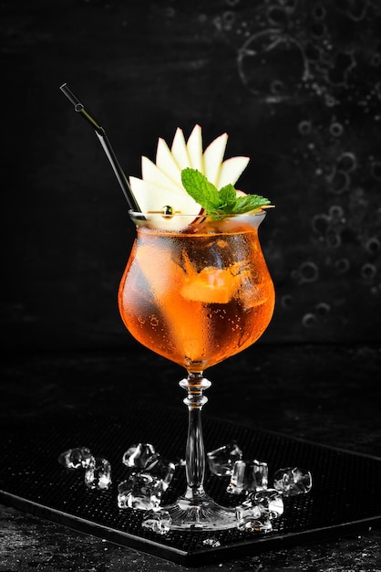 Cocktail in a glass - Aperol spritz. on a black stone background. Menu bar. Alcohol.