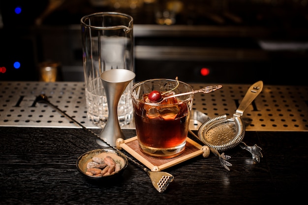 Cocktail glass filled with strong and sweet summer cocktail decorated with cherry