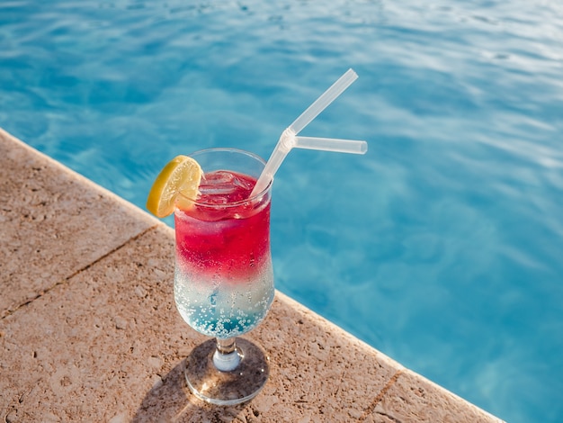 Cocktail glass next to a pool