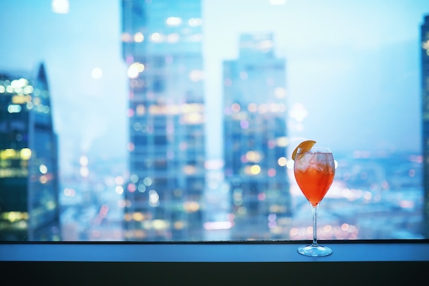 Cocktail glasses on the windowsill by the glass of a tall building