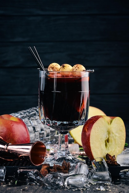 A cocktail of hot red wine wine on a black wooden\
background