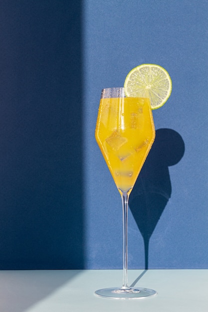 Foto cocktail in een glas met gekleurde achtergronden en schaduwen op de muur