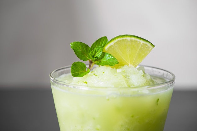 Cocktail juice with lime, mint and ice. Bar drink accessories on black table background.