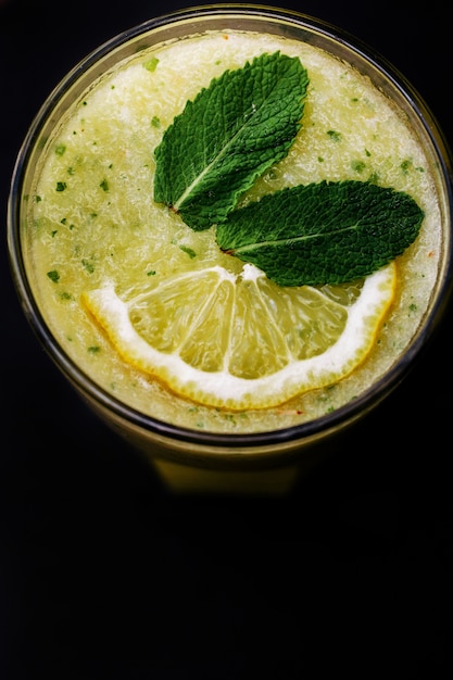 Cocktail of lemon and mint stands on black background