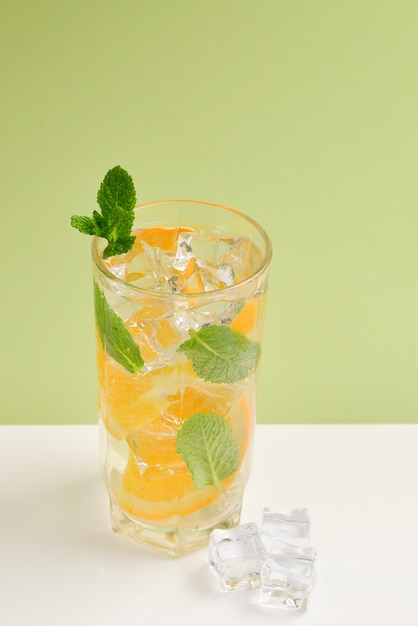 Cocktail met citroen en munt op een groene achtergrond. Ruimte kopiëren.