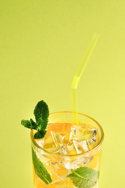 Cocktail met citroen en munt op een groene achtergrond. Ruimte kopiëren.