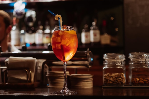 Cocktail met ijs en een schijfje sinaasappel in een glas op de bar