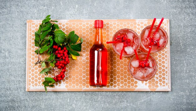 Cocktail met ijs en ingrediënten op een stenen dienblad.