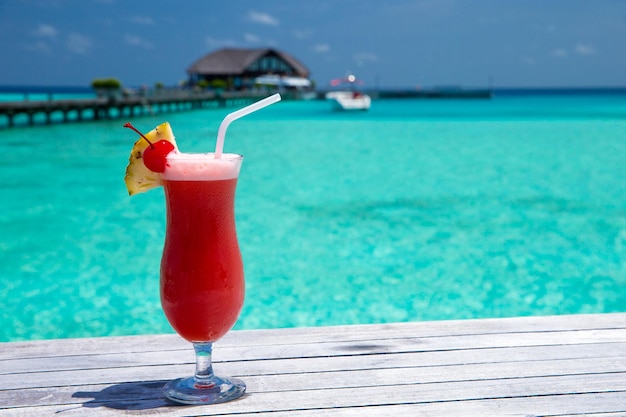 Cocktail met onduidelijk beeldstrand op achtergrond