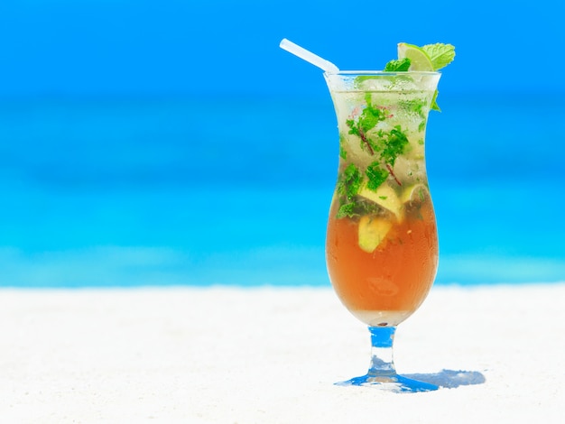 Cocktail met onduidelijk beeldstrand op achtergrond