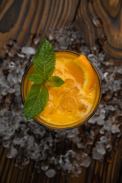 Cocktail Orange juice with mint and ice rustic wooden table