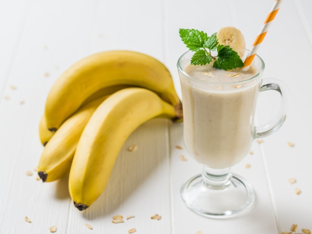 Cocktail orange tube in a glass with a banana smoothie